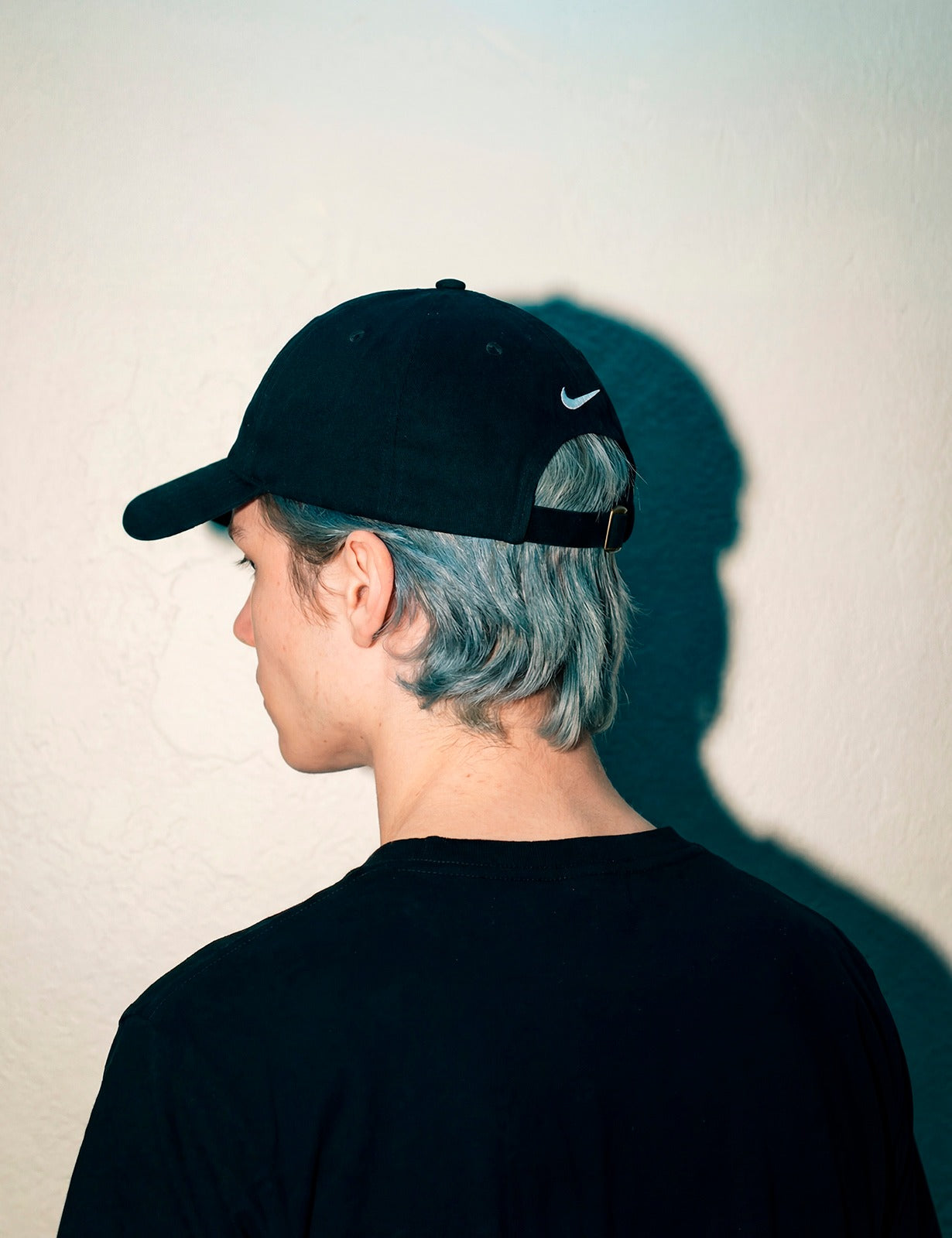 Rear angle of a man wearing a black MORE ORANGE™ dad hat in an urban setting