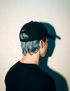 Back view of a black MORE ORANGE™ dad hat showing clean unstructured fit